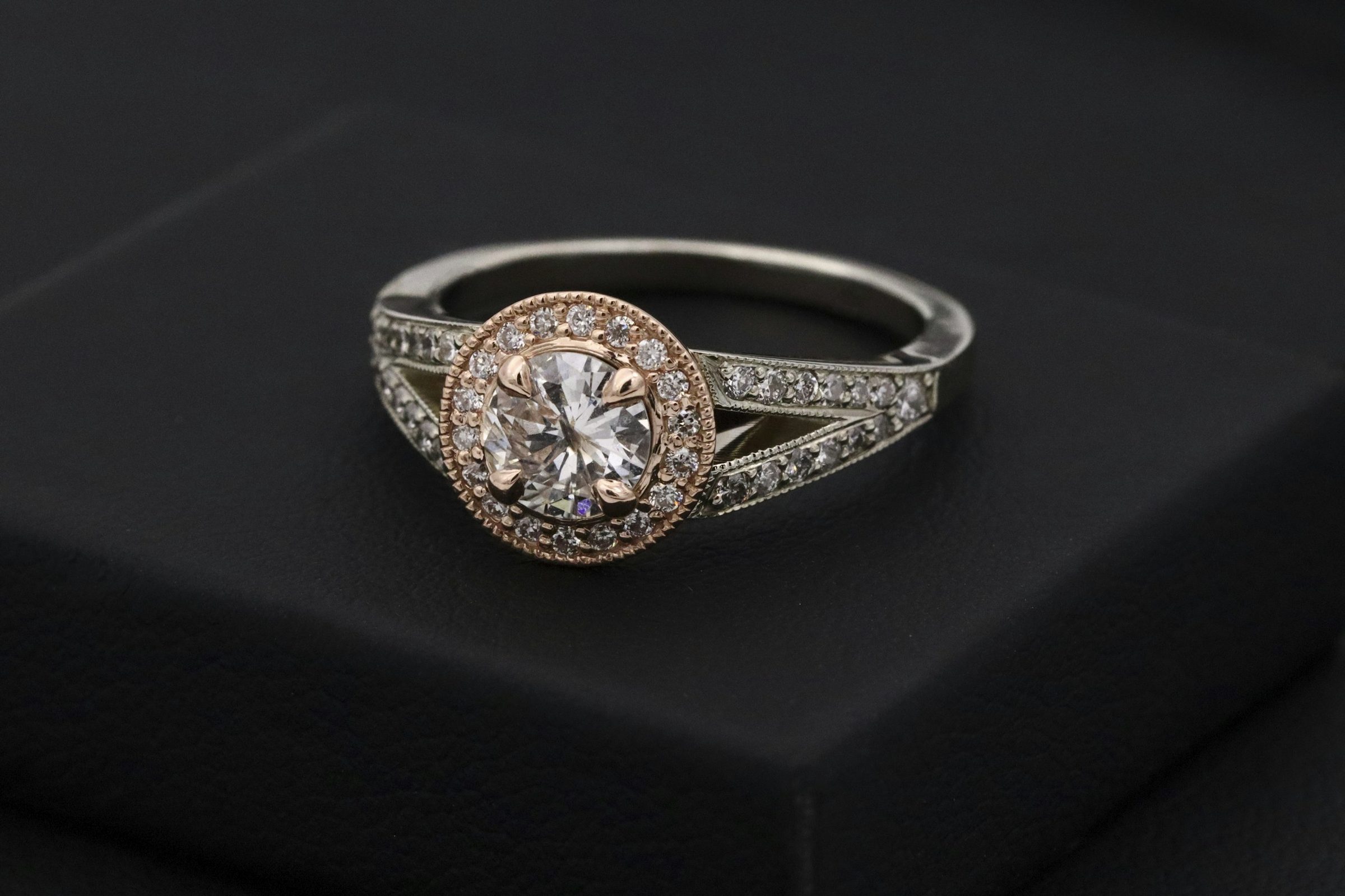 A halo diamond engagement ring in rose and white gold